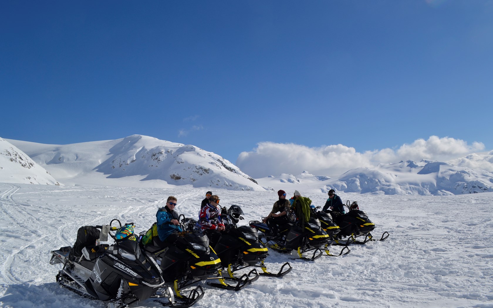En gruppe snøskuterførere på fjellet.