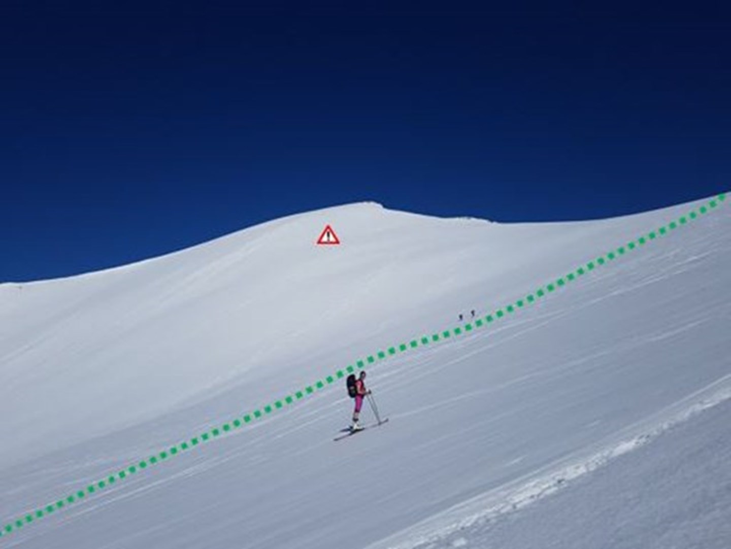 En skiløper følger tegnet rute opp til Smørbottind, med Kvasstinden i bakgrunnen.