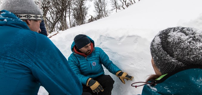 En gruppe fra Snøskredvarslingen undersøker lagene i en snøprofil.