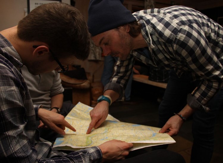 Et par som studerer kart og planlegger hvor morgendagens tur skal gå.
